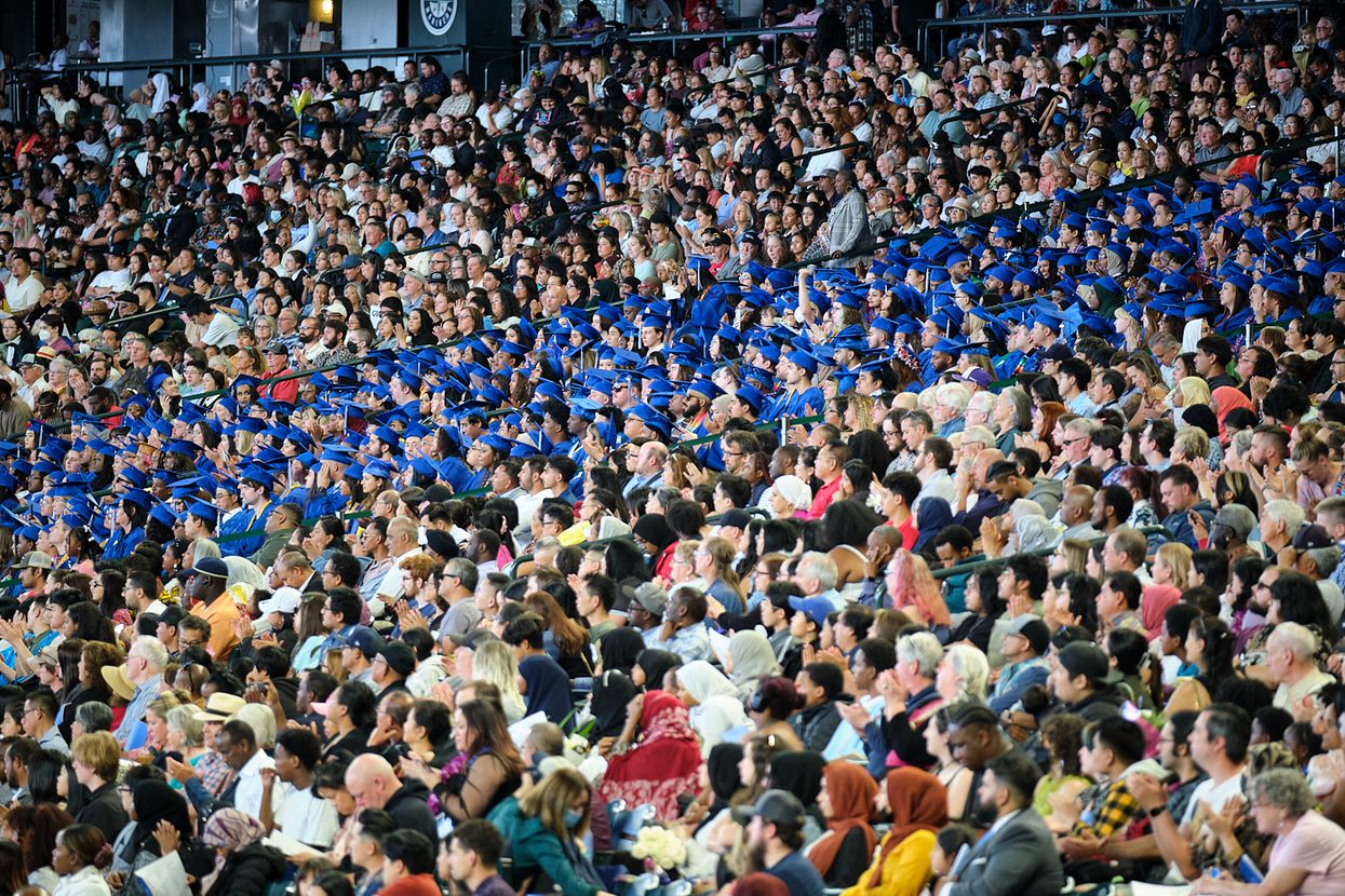 a view of the crowd including graduates and their guest in the stadium seats